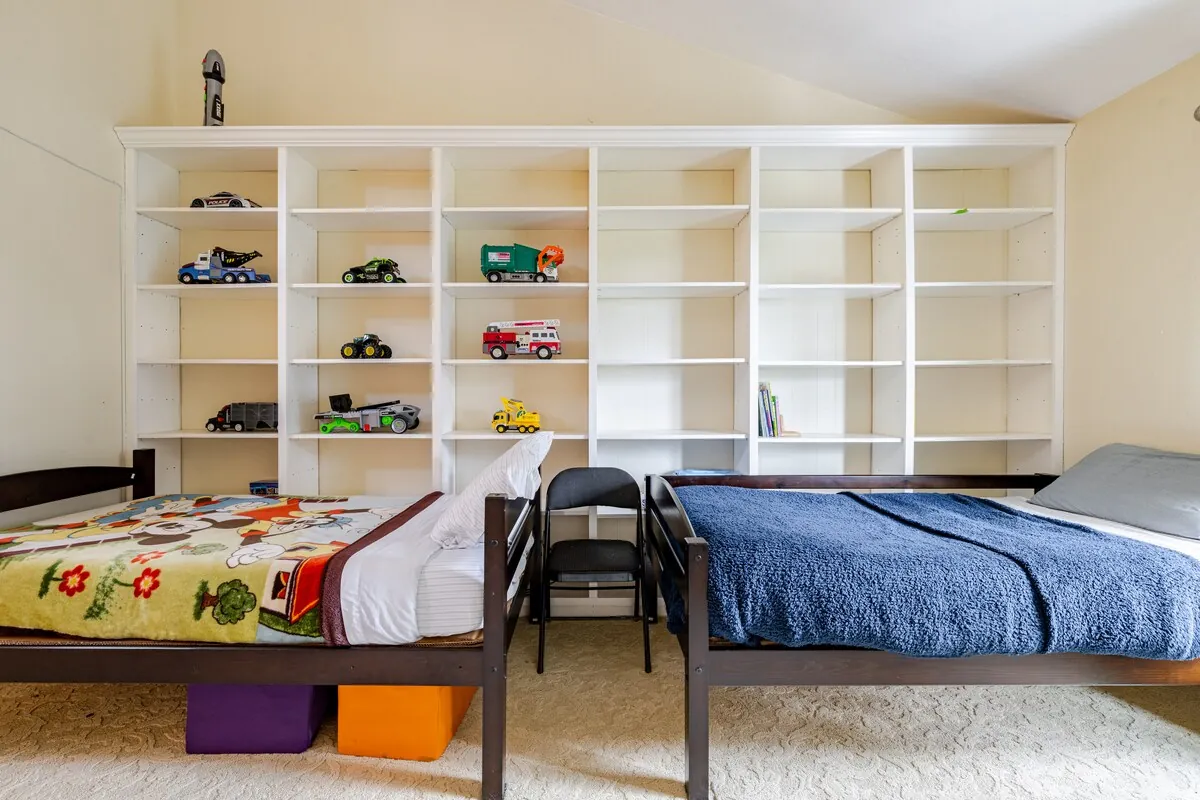 Kids room with twin beds and built-in shelving