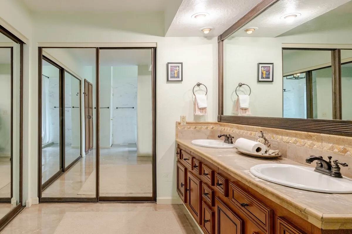 En-suite bathroom with double sinks and mirror closets