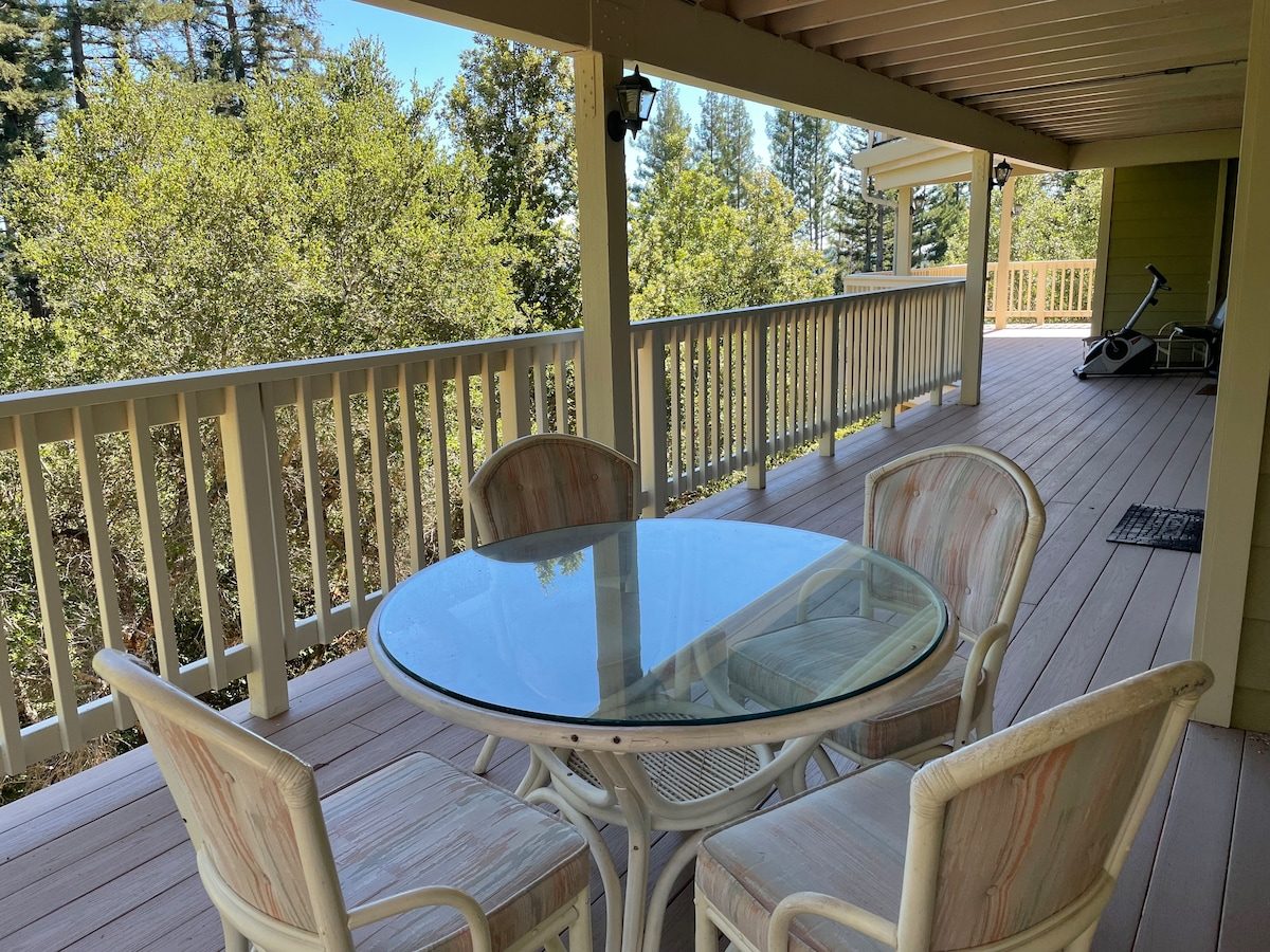 Covered deck with dining table and forest views at The Crow's Nest Retreat