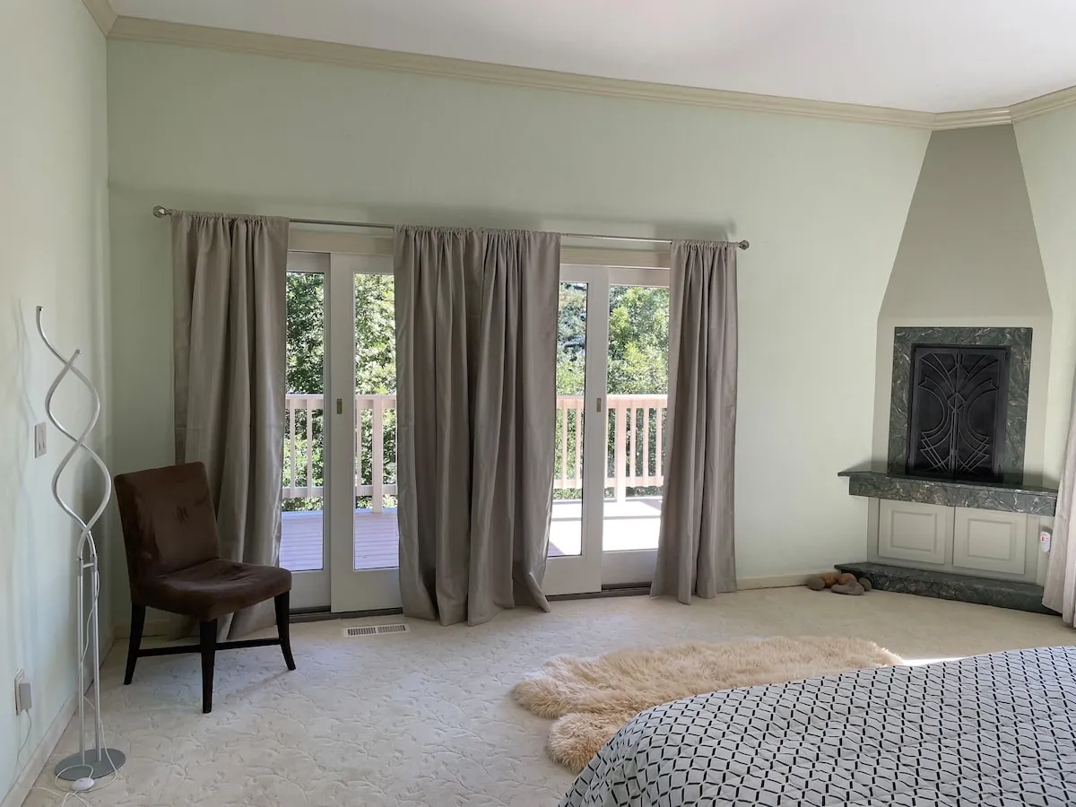 Primary suite with marble fireplace and French doors to deck